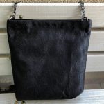 Front of black fabric bag on the bench