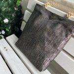 Side face of the black herringbone design textured bag on the bench