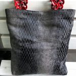 Front of the fabric bag with red hanger on the bench