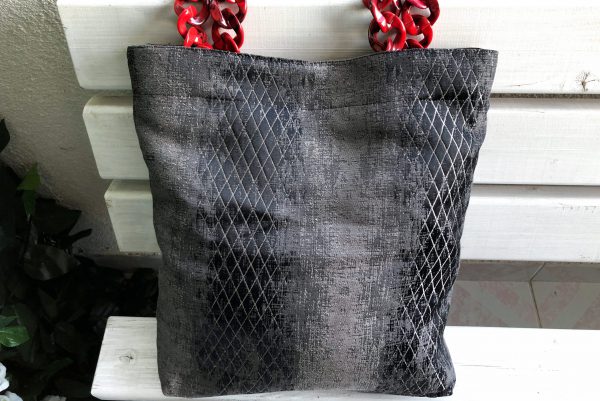 Front of the fabric bag with red hanger on the bench