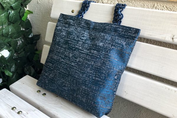 Side face of striped blue fabric bag on the bench