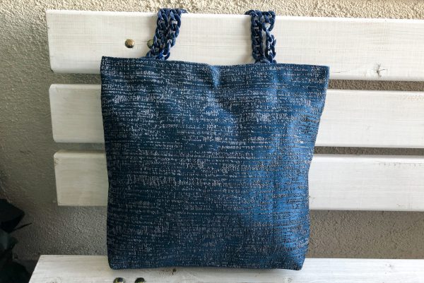 Front of striped blue fabric bag on the bench